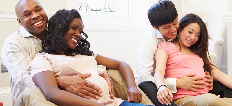 two pregnant couples on the floor in a course